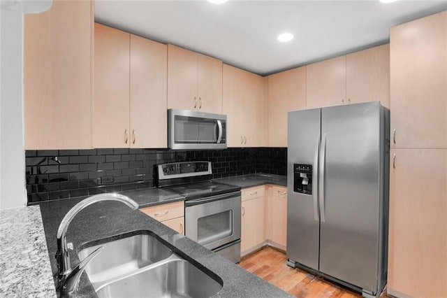 860 Peachtree St NE Unit 909, Atlanta, GA 30308 - kitchen with stainless steel appliances, a sink, light brown cabinets, light wood finished floors, and decorative backsplash