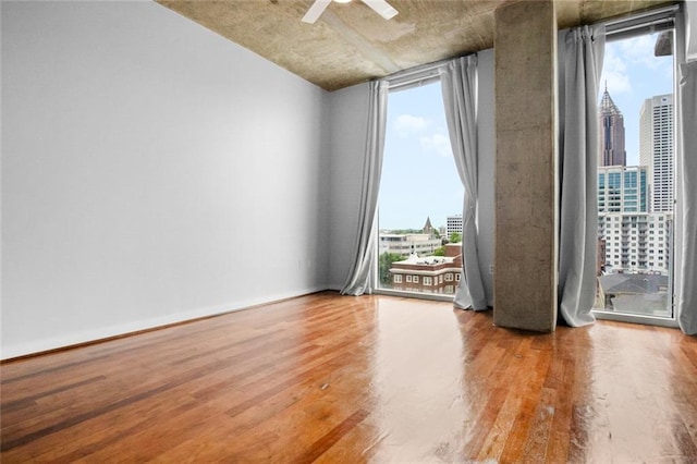 860 Peachtree St NE Unit 909, Atlanta, GA 30308 - spare room featuring wood finished floors, a skyline view, and plenty of natural light