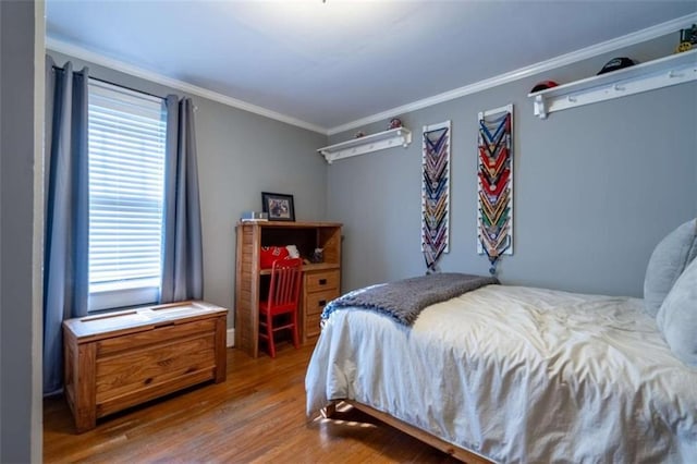 bedroom featuring ornamental molding and wood finished floors