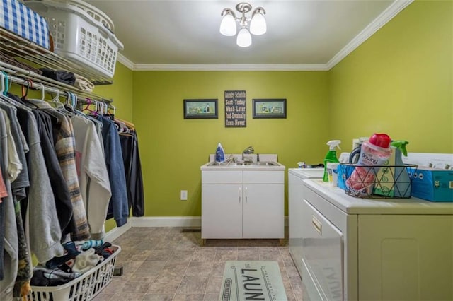 clothes washing area with cabinet space, washing machine and dryer, crown molding, and a sink