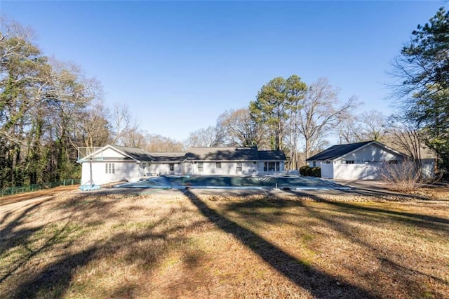 ranch-style house featuring a front yard and a fenced in pool