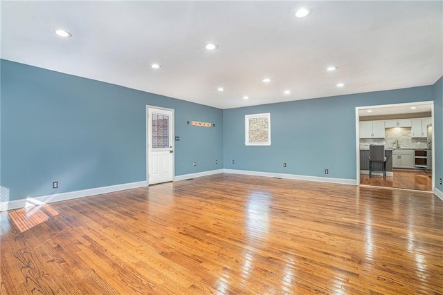 empty room featuring sink and light hardwood / wood-style flooring