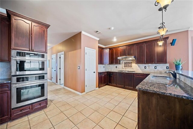 kitchen with sink, light tile patterned flooring, hanging light fixtures, and appliances with stainless steel finishes