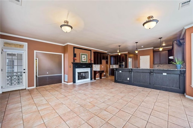 kitchen featuring a fireplace, light tile patterned flooring, a kitchen breakfast bar, ornamental molding, and dark brown cabinets