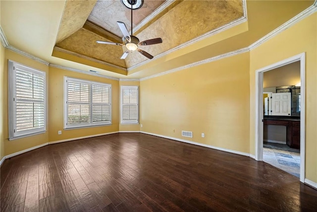 spare room featuring wood-type flooring, ceiling fan, a tray ceiling, and crown molding