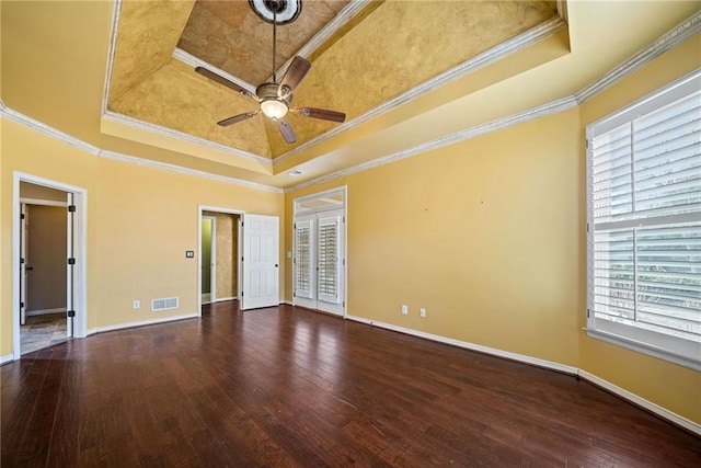 empty room with hardwood / wood-style flooring, a raised ceiling, and ornamental molding