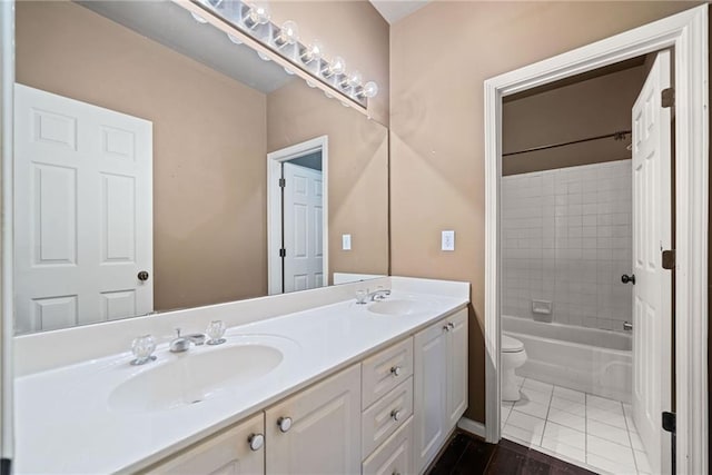 full bathroom featuring wood-type flooring, tiled shower / bath, vanity, and toilet