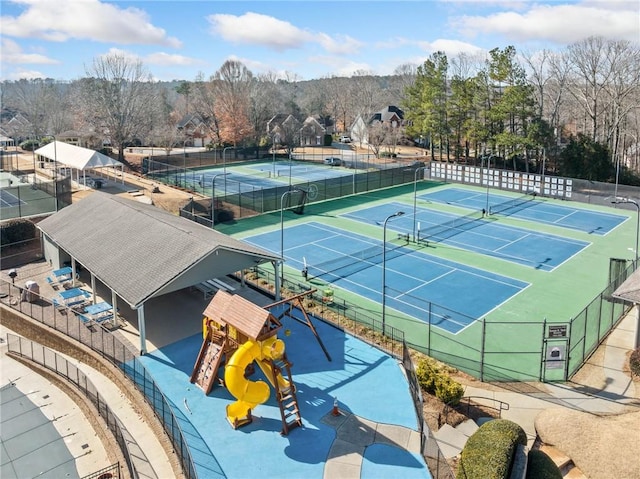 view of tennis court with a playground