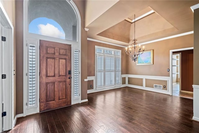 foyer entrance featuring a notable chandelier, dark hardwood / wood-style flooring, and a tray ceiling