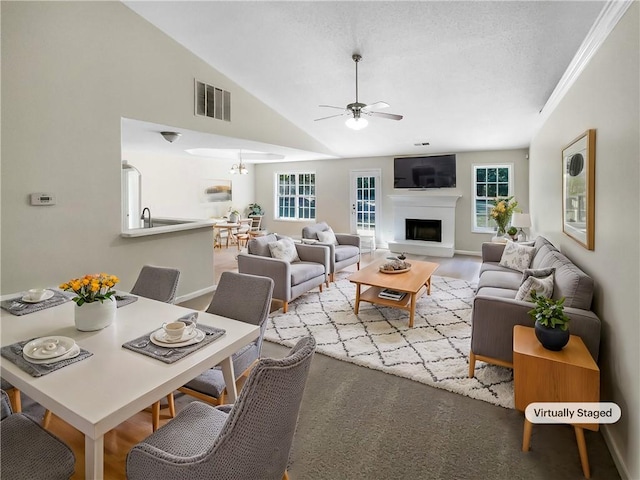 living room with crown molding, ceiling fan, and vaulted ceiling