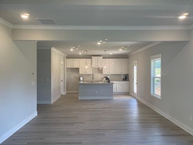 kitchen featuring sink, a center island with sink, light hardwood / wood-style floors, and white cabinetry