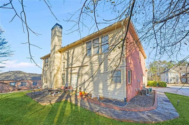 rear view of house featuring cooling unit, a patio area, and a yard