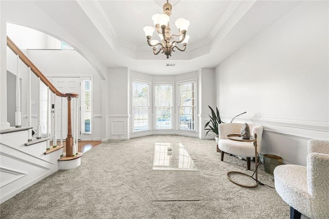 sitting room featuring a chandelier, carpet floors, a raised ceiling, and crown molding