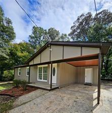 view of front of house with driveway and a carport