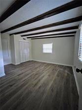 interior space with beam ceiling and wood finished floors