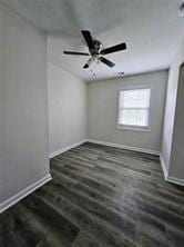 unfurnished room with wood finished floors, ceiling fan, and baseboards