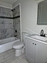 bathroom featuring tile patterned floors, toilet, shower / bathing tub combination, and vanity