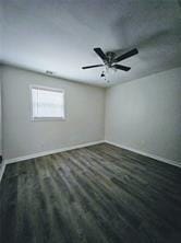 unfurnished room featuring wood finished floors, ceiling fan, and baseboards