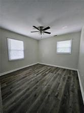 unfurnished room featuring a ceiling fan, baseboards, and wood finished floors