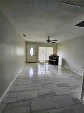 unfurnished living room with a ceiling fan and baseboards