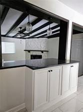 kitchen featuring white cabinets, dark countertops, and ceiling fan