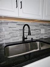 room details with dark countertops, white cabinetry, a sink, and mail area