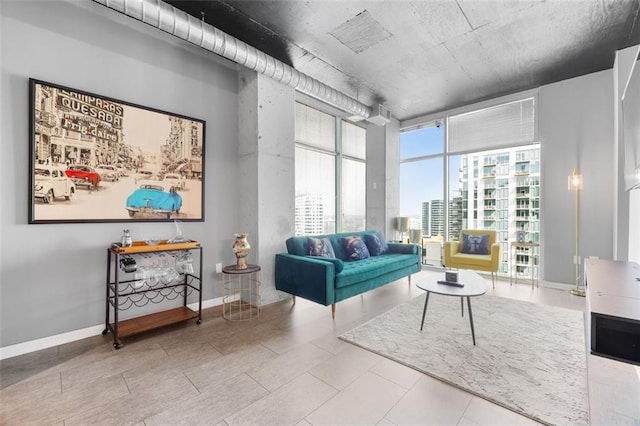 living area featuring a view of city, baseboards, and expansive windows