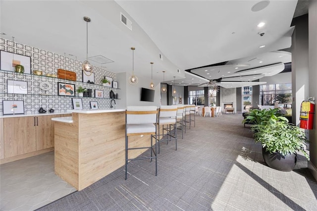 kitchen with a healthy amount of sunlight, visible vents, recessed lighting, light brown cabinetry, and modern cabinets