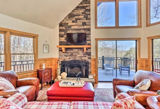 living room with wooden walls, a fireplace, high vaulted ceiling, and hardwood / wood-style flooring