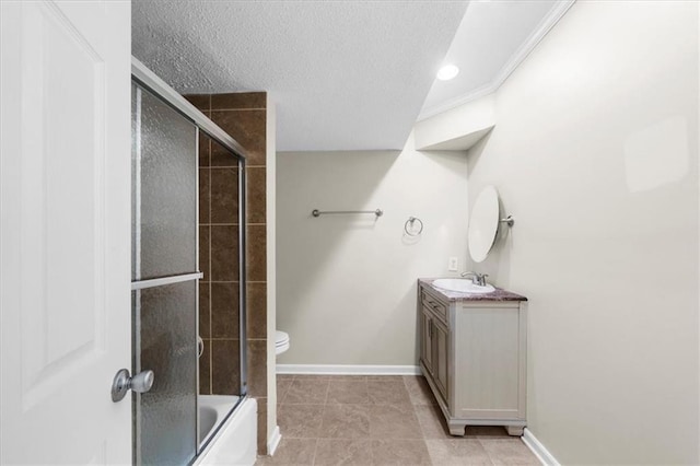 full bathroom with tile patterned floors, a textured ceiling, vanity, shower / bath combination with glass door, and toilet