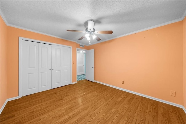 unfurnished bedroom featuring ceiling fan, crown molding, a textured ceiling, and hardwood / wood-style flooring