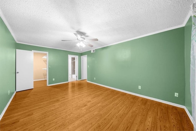 unfurnished bedroom featuring ceiling fan, a walk in closet, wood-type flooring, and a textured ceiling