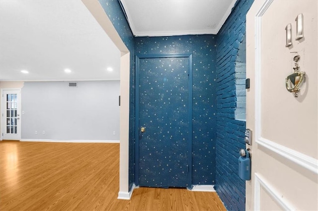 spare room featuring wood-type flooring and ornamental molding