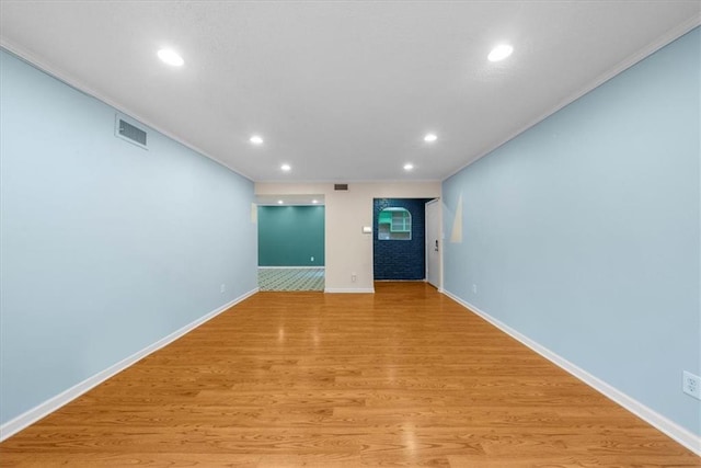 unfurnished living room with light wood-type flooring and ornamental molding