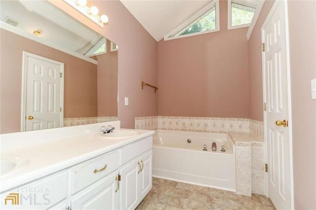 full bathroom featuring vaulted ceiling, a garden tub, and double vanity