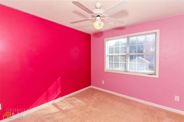 carpeted empty room featuring baseboards and ceiling fan
