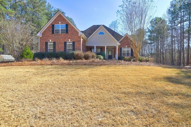 view of front of home featuring brick siding and a front yard