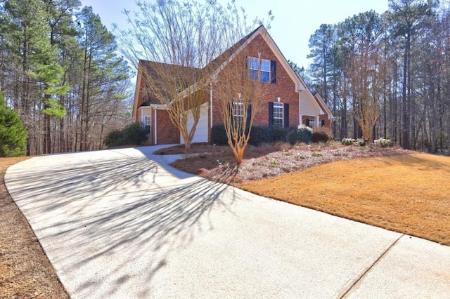 view of front facade featuring a garage, brick siding, and driveway