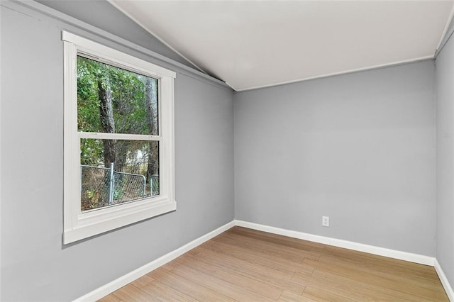 unfurnished room featuring lofted ceiling and light hardwood / wood-style floors