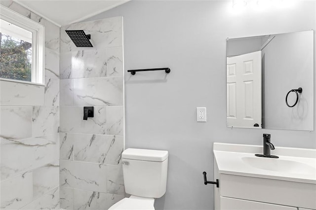 bathroom featuring vanity, tiled shower, and toilet