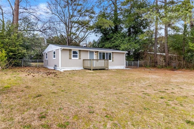 back of house featuring a lawn and a deck