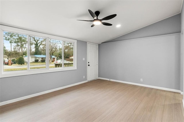 spare room with vaulted ceiling, ceiling fan, and light wood-type flooring