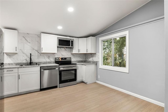 kitchen with white cabinetry, appliances with stainless steel finishes, sink, and backsplash