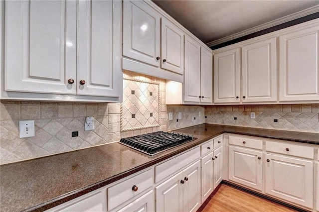 1595 Chadberry Way, Lawrenceville, GA 30043 - kitchen with stainless steel gas cooktop, dark countertops, white cabinets, and ornamental molding