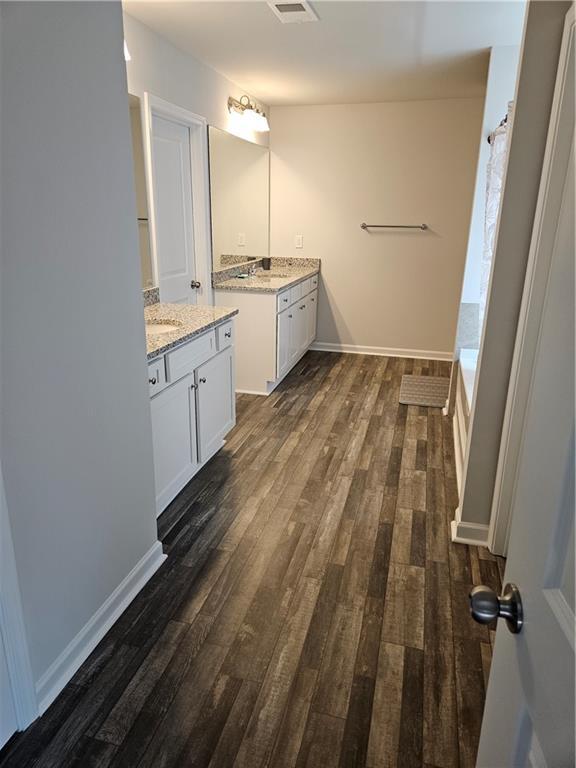 bathroom featuring hardwood / wood-style flooring, vanity, and a washtub