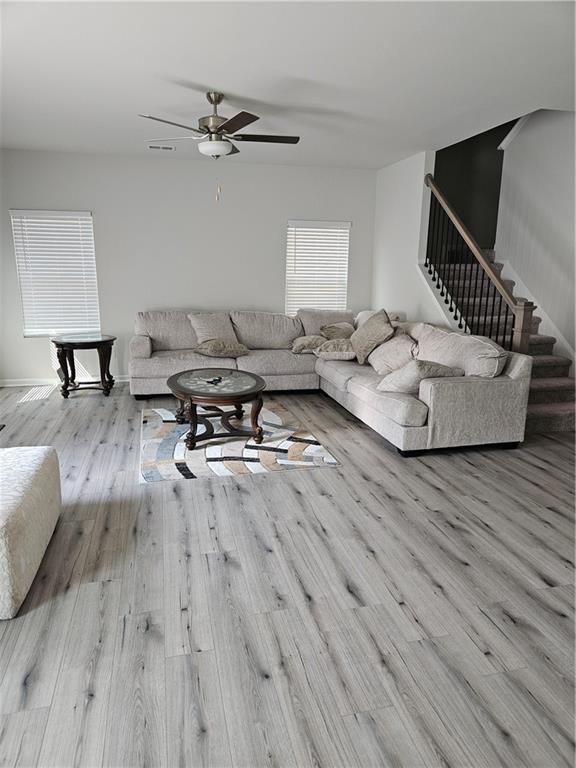 living room featuring ceiling fan and light hardwood / wood-style floors