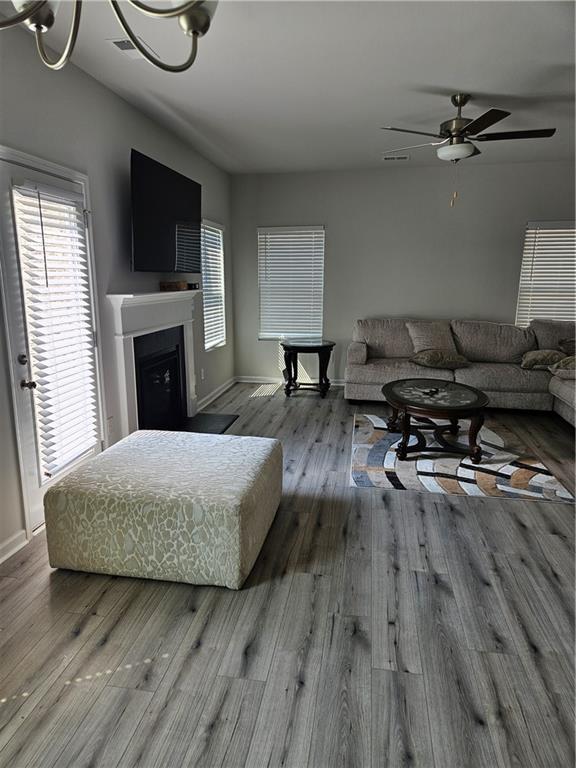 living room featuring wood-type flooring and ceiling fan