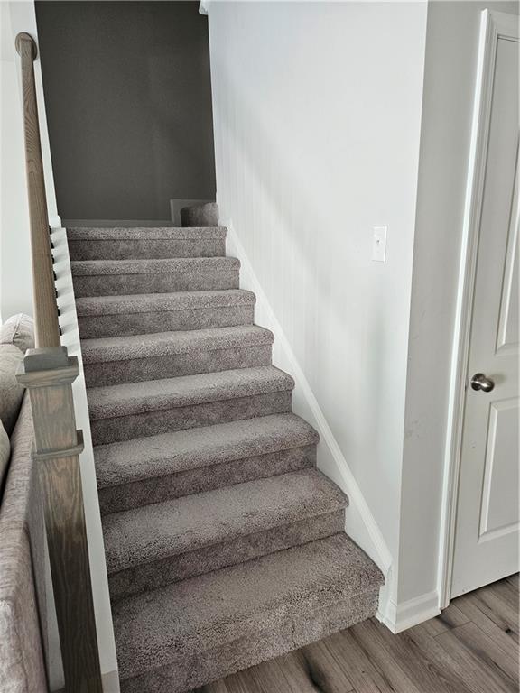 staircase with hardwood / wood-style flooring