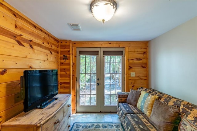 doorway to outside featuring french doors, a wealth of natural light, and wooden walls