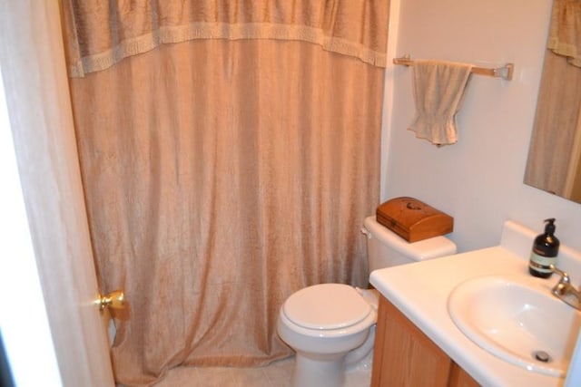 bathroom featuring vanity, toilet, curtained shower, and tile patterned flooring